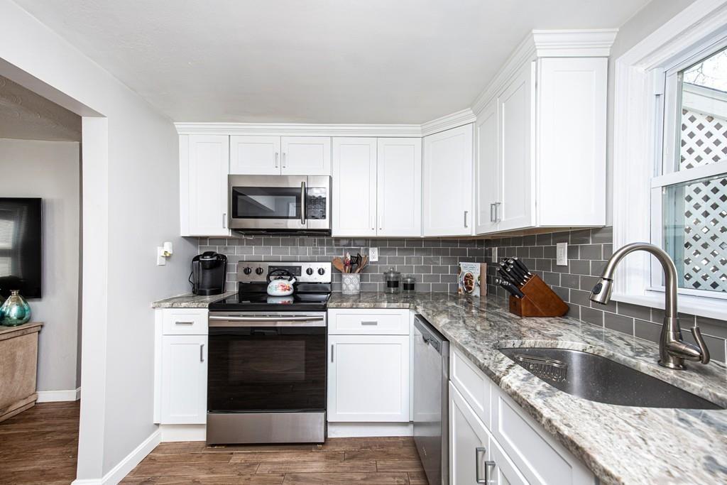 21 Forest Street Peabody, MA 01960 - Photo 9 of 29 a kitchen with granite countertop a sink and a stove top oven