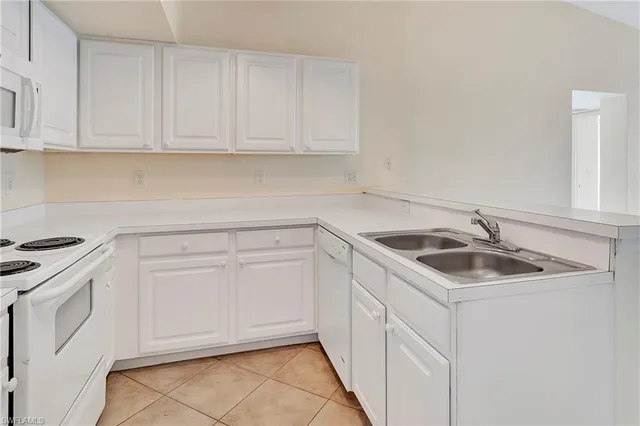 a kitchen with white cabinets and white appliances