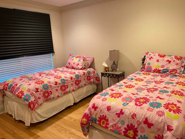 a bedroom with two beds and a lamp on dresser