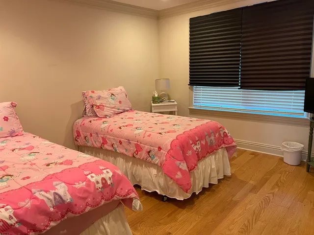 a bedroom with two beds and a potted plant