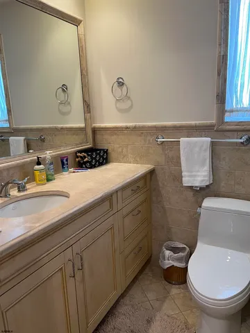 a bathroom with a granite countertop toilet sink and mirror