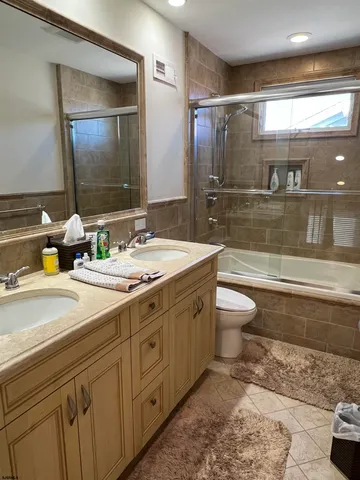 a bathroom with a double vanity sink toilet and shower