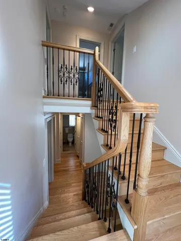 a view of staircase with lots of frames on wall and wooden floor