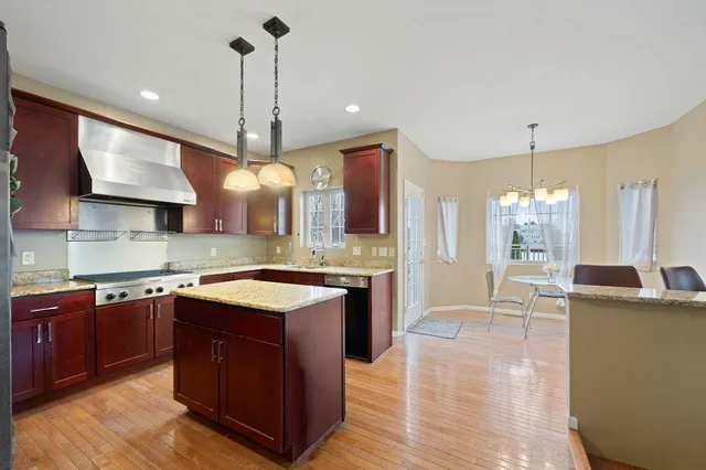 a kitchen with stainless steel appliances granite countertop a sink a stove and a refrigerator