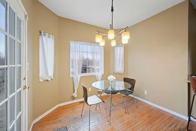 a view of a hallway with wooden floor and a chandelier
