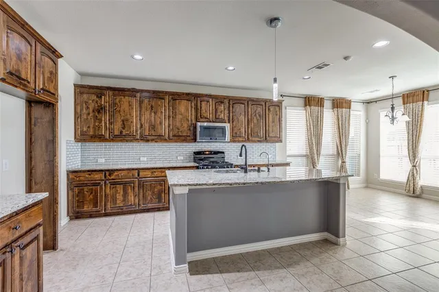 a kitchen with stainless steel appliances granite countertop a sink counter space cabinets and a large window