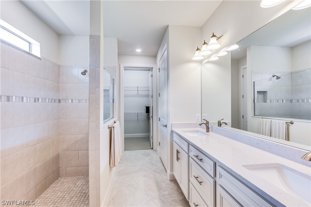 16495 Windsor Way Alva, FL 33920 - Photo 15 of 19 a spacious bathroom with a double vanity sink mirror double shower and a bathtub