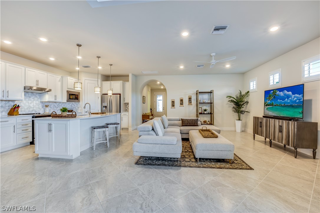 16495 Windsor Way Alva, FL 33920 - Photo 4 of 19 a living room with furniture kitchen view and a flat screen tv