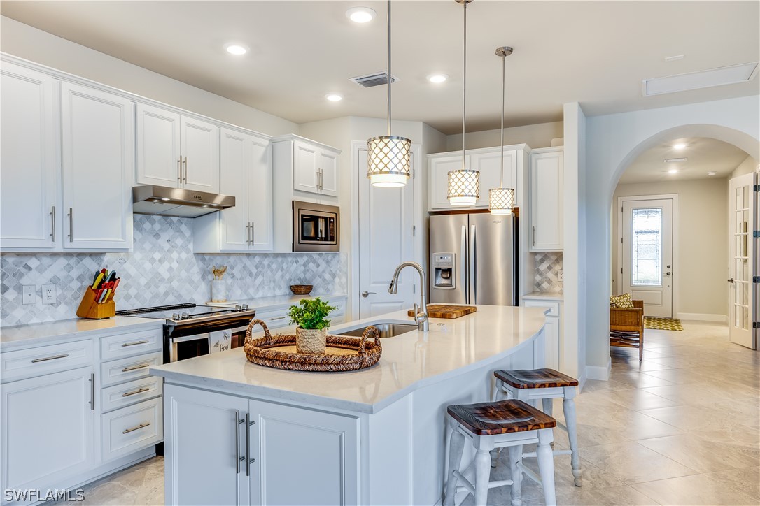 16495 Windsor Way Alva, FL 33920 - Photo 7 of 19 a kitchen with stainless steel appliances granite countertop a sink a stove and a refrigerator