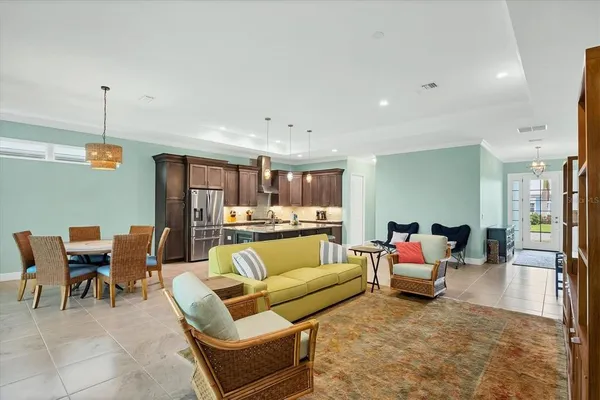 a living room with furniture kitchen view and a wooden floor