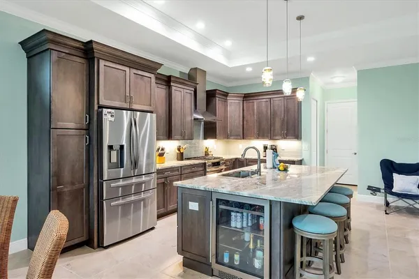 a kitchen with stainless steel appliances granite countertop a refrigerator a sink and a stove