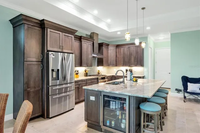 a kitchen with stainless steel appliances granite countertop a refrigerator a sink and a stove