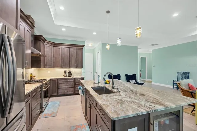 a kitchen with stainless steel appliances granite countertop a sink stove and refrigerator
