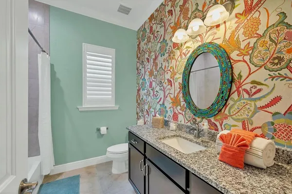 a bathroom with a granite countertop toilet a sink and a mirror