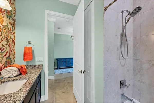 a bathroom with a granite countertop sink a mirror and shower