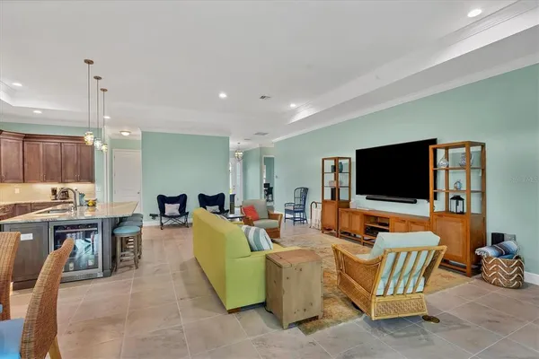 a living room with furniture kitchen view and a flat screen tv