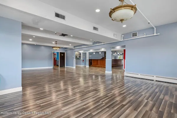an empty room with wooden floor and large windows