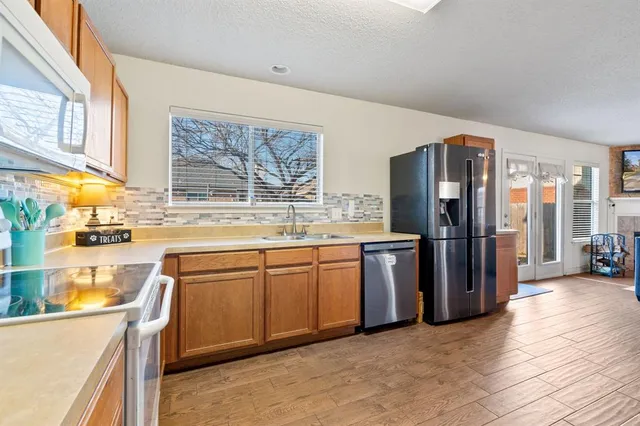 a kitchen with stainless steel appliances granite countertop a refrigerator and a sink