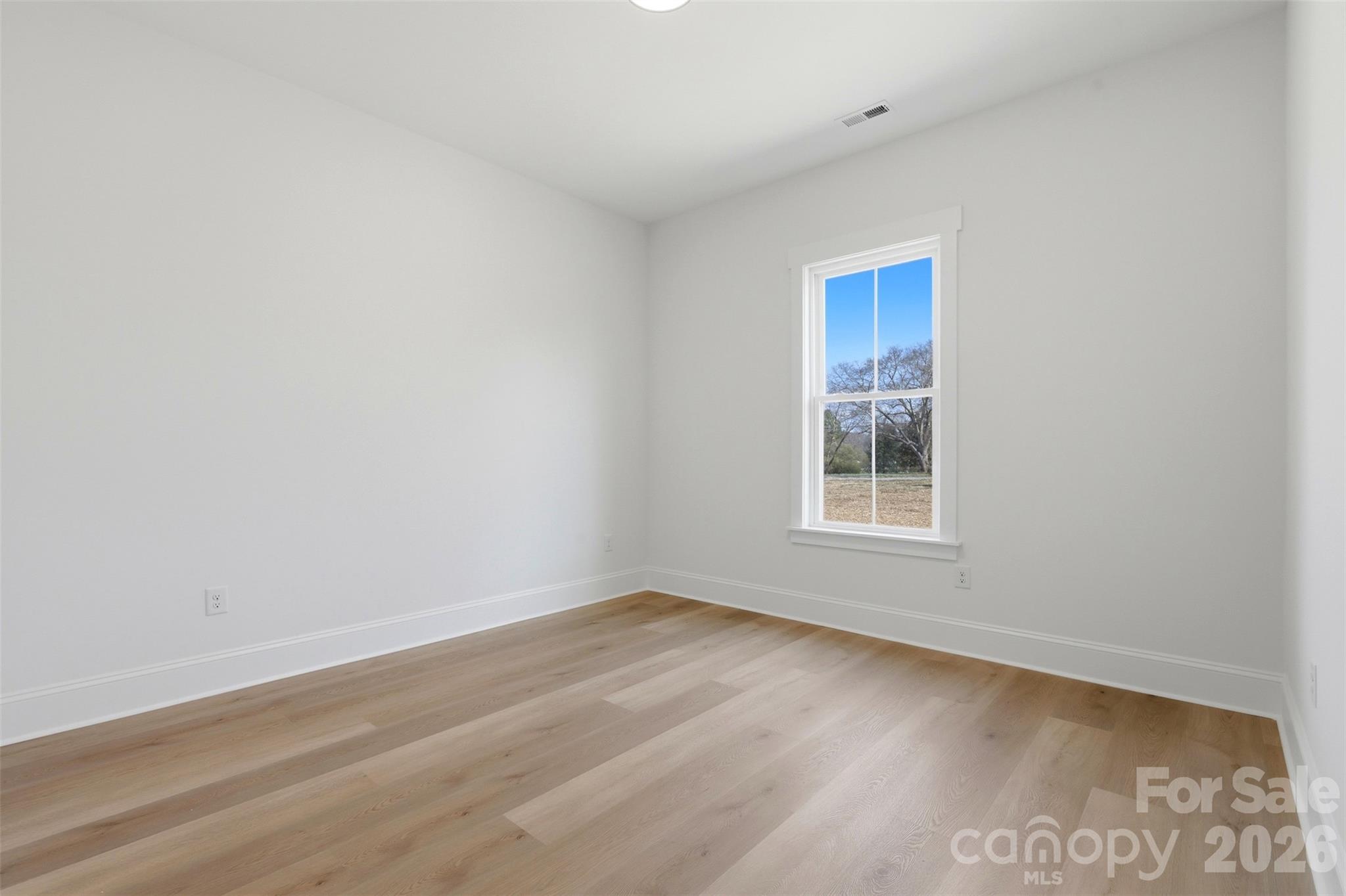 4748 Polk Ford Road Stanfield, NC 28163 - Photo 35 of 47 a view of an empty room with wooden floor and a window