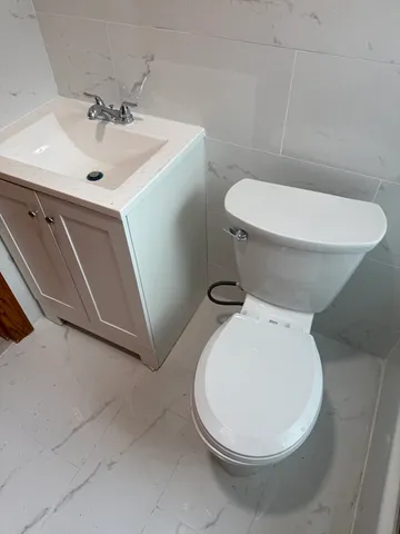 a white toilet sitting next to a bathroom sink