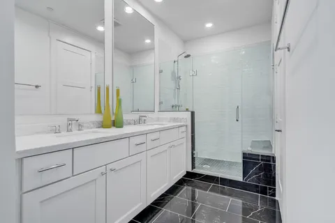 a bathroom with a double sink shower and a mirror