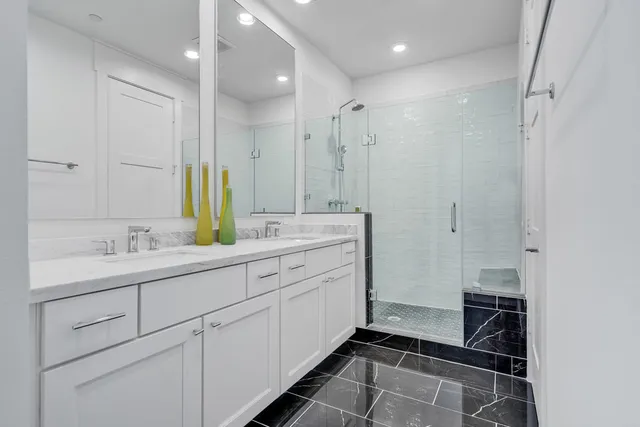 a bathroom with a double sink shower and a mirror