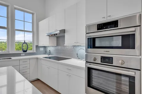 a kitchen with stainless steel appliances granite countertop a sink and a microwave