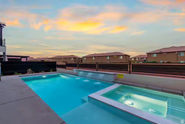 2600 Ocotillo Way, Unit 56 Santa Clara, UT 84765 - Photo 8 of 33 Pool at dusk featuring a residential view, a pool with connected hot tub, and a patio