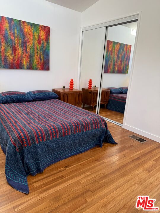 5128 East Wardlow Road Long Beach, CA 90808 - Photo 14 of 35 a bedroom with a bed and a painting on the wall