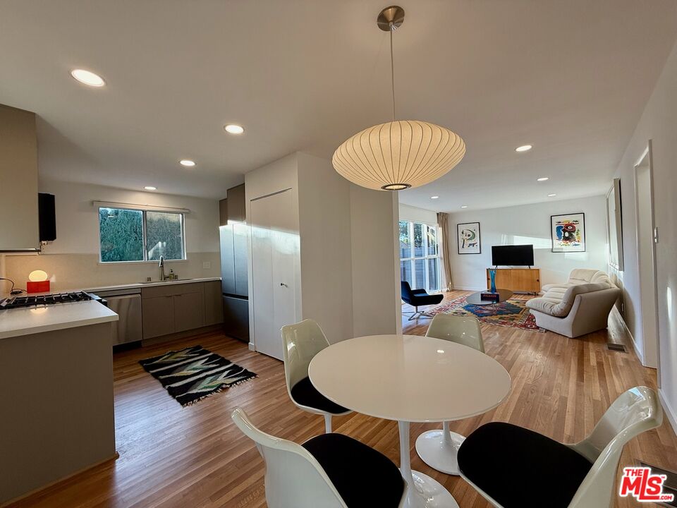 5128 East Wardlow Road Long Beach, CA 90808 - Photo 10 of 35 a living room with furniture a table and a flat screen tv