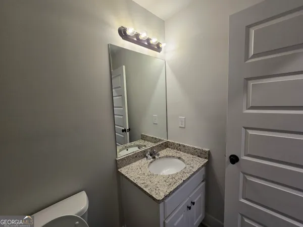 a bathroom with a granite countertop sink and a mirror