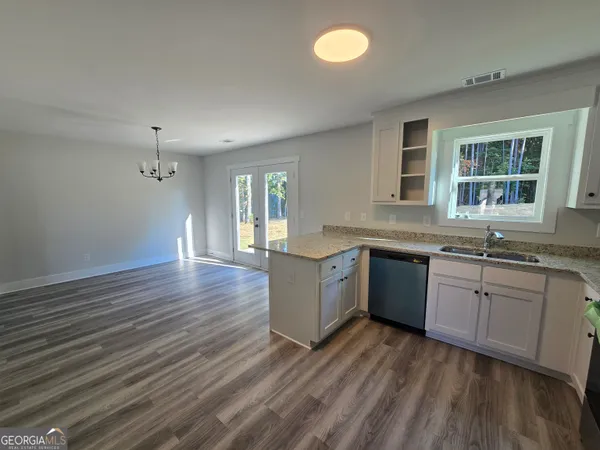 a kitchen with a sink and wooden floor