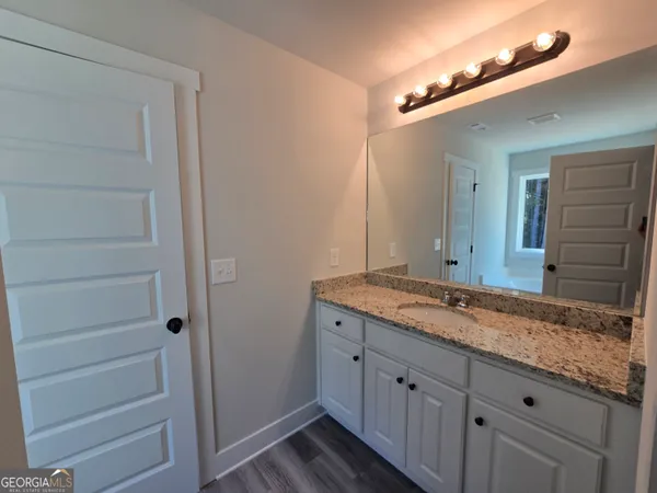 a bathroom with a granite countertop sink and a mirror