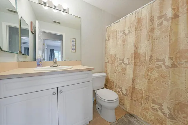 a bathroom with a toilet a sink a shower and a mirror