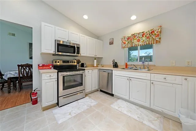 a kitchen with white cabinets stainless steel appliances and sink