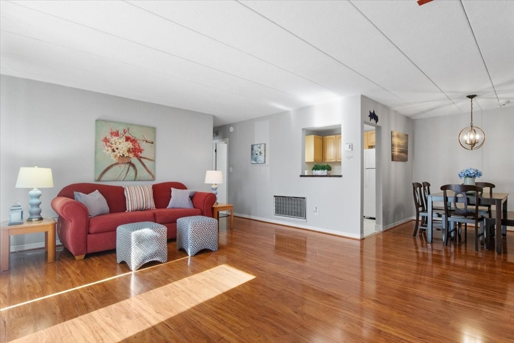 40 High Street, Unit 207 Dedham, MA 02026 - Photo 11 of 41 a living room with furniture a dining table and wooden floor