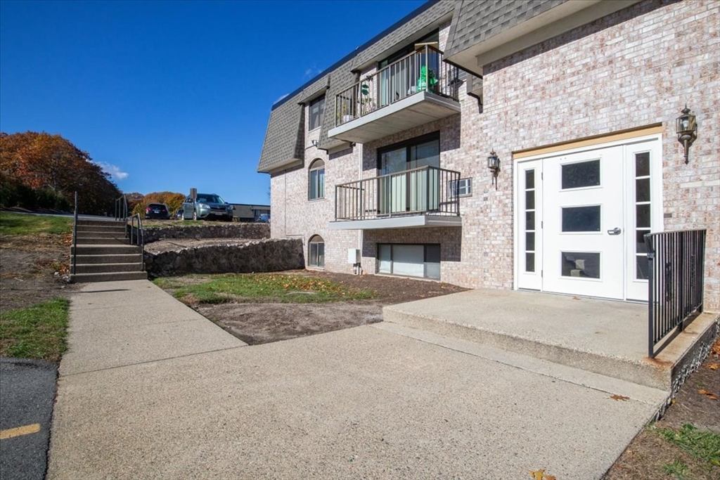 40 High Street, Unit 207 Dedham, MA 02026 - Photo 3 of 41 a front view of a building with a garden and parking space