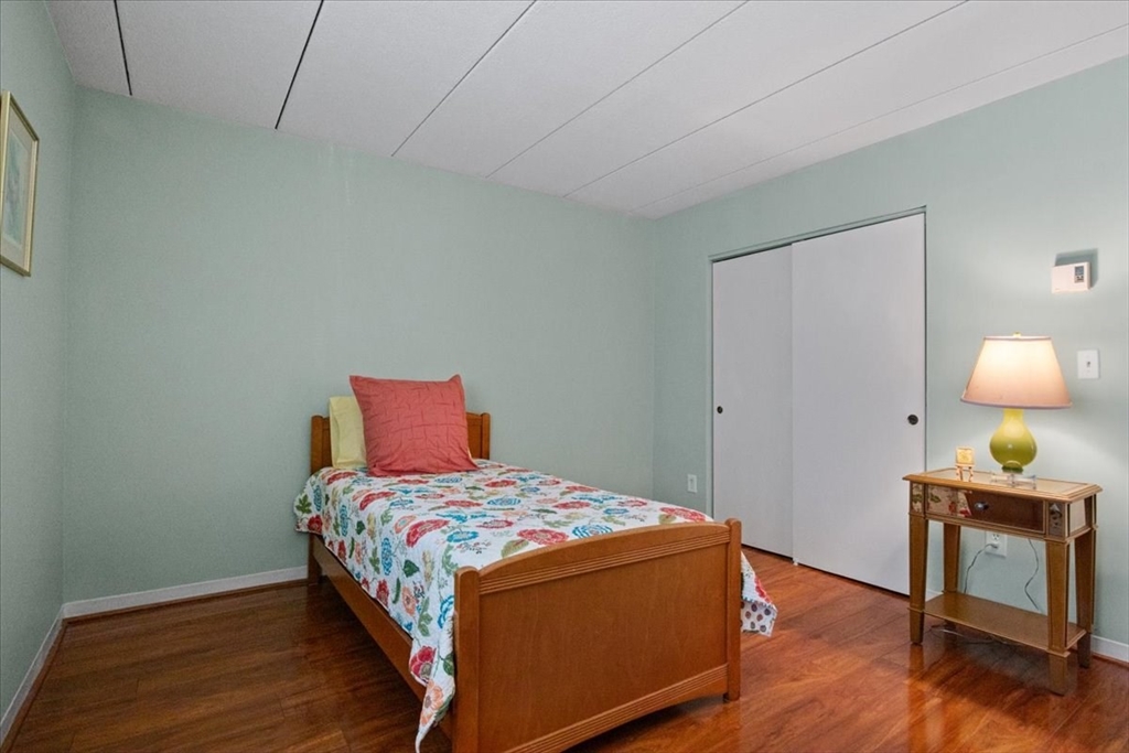 40 High Street, Unit 207 Dedham, MA 02026 - Photo 31 of 41 a bedroom with a bed and a lamp on the dresser