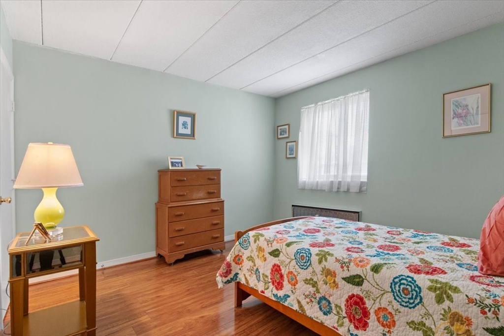 40 High Street, Unit 207 Dedham, MA 02026 - Photo 32 of 41 a bedroom with a bed and a lamp on dresser