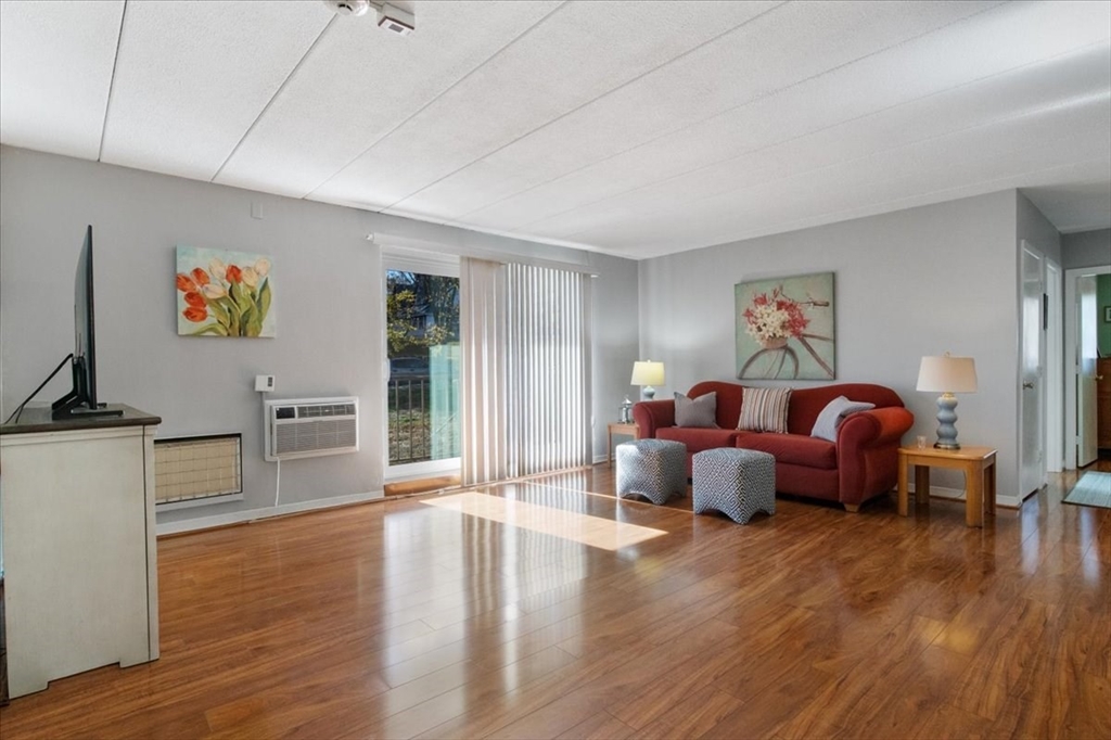 40 High Street, Unit 207 Dedham, MA 02026 - Photo 6 of 41 a living room with furniture and a wooden floor
