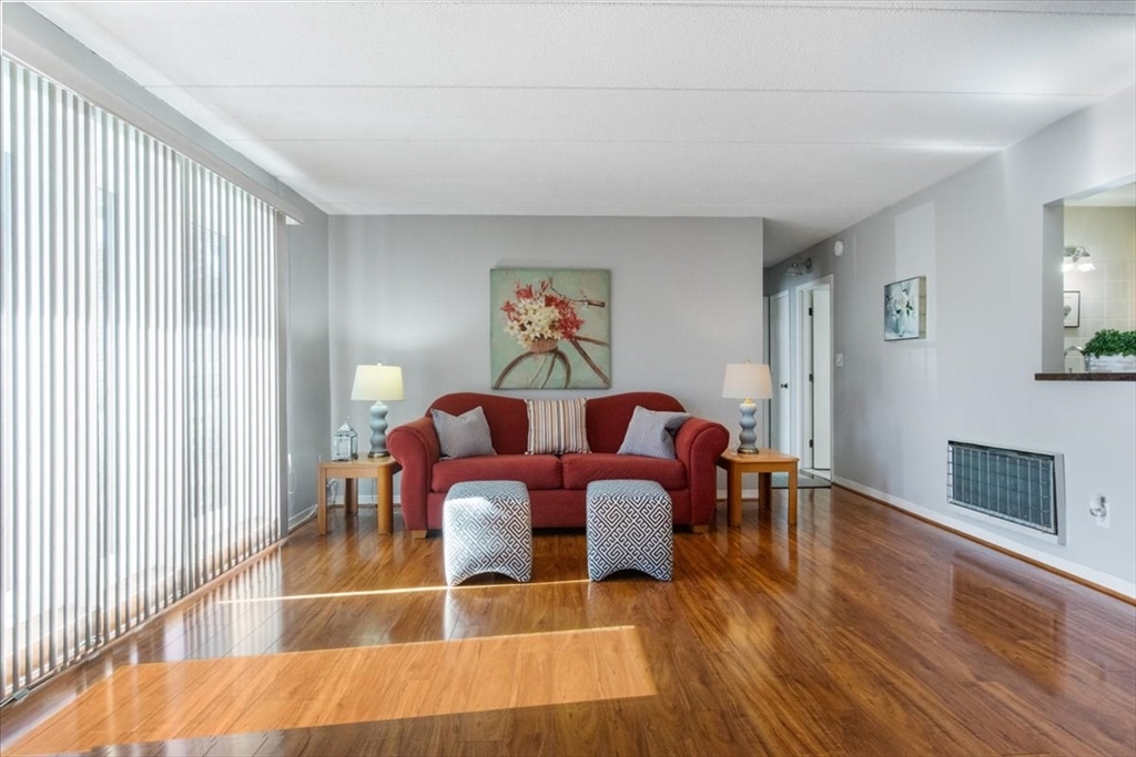 40 High Street, Unit 207 Dedham, MA 02026 - Photo 10 of 41 a living room with furniture a wooden floor and a fireplace
