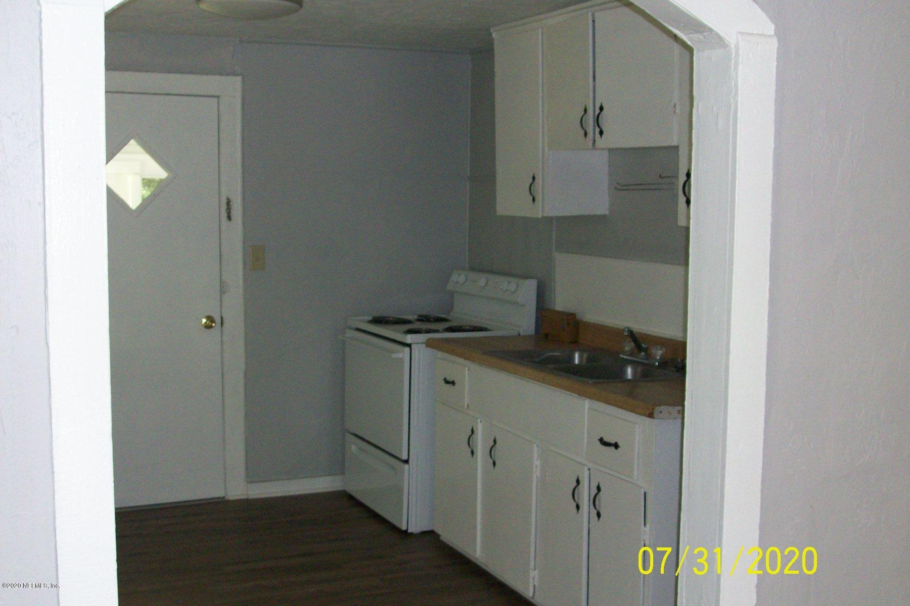524 St Clair Street Starke, FL 32091 - Photo 7 of 20 a kitchen with stainless steel appliances granite countertop a sink and a stove with wooden floor