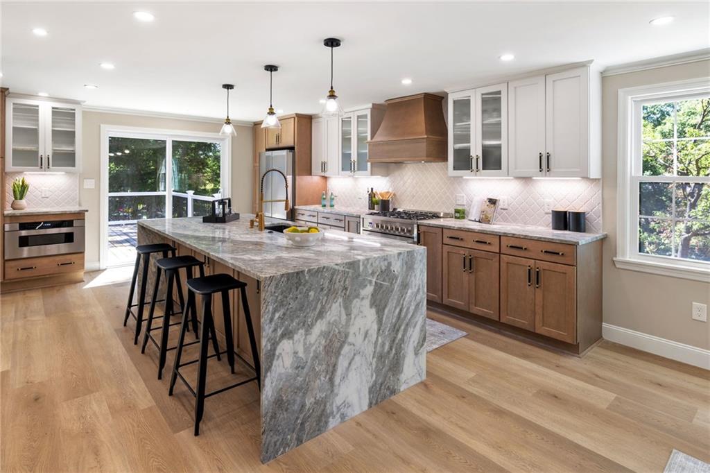 8241 Thompson Run Road Pittsburgh, PA 15237 - Photo 14 of 47 a kitchen with stainless steel appliances granite countertop a stove a sink dishwasher and a refrigerator with wooden floor