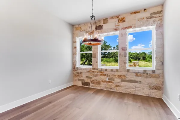 a view of a kitchen with wooden floor and natural light