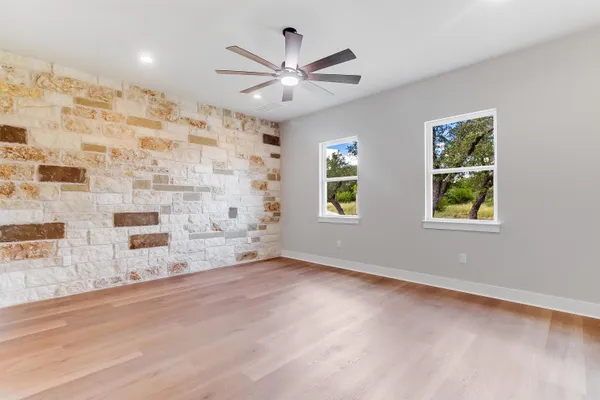 a view of wooden floor and a chandelier fan in a room