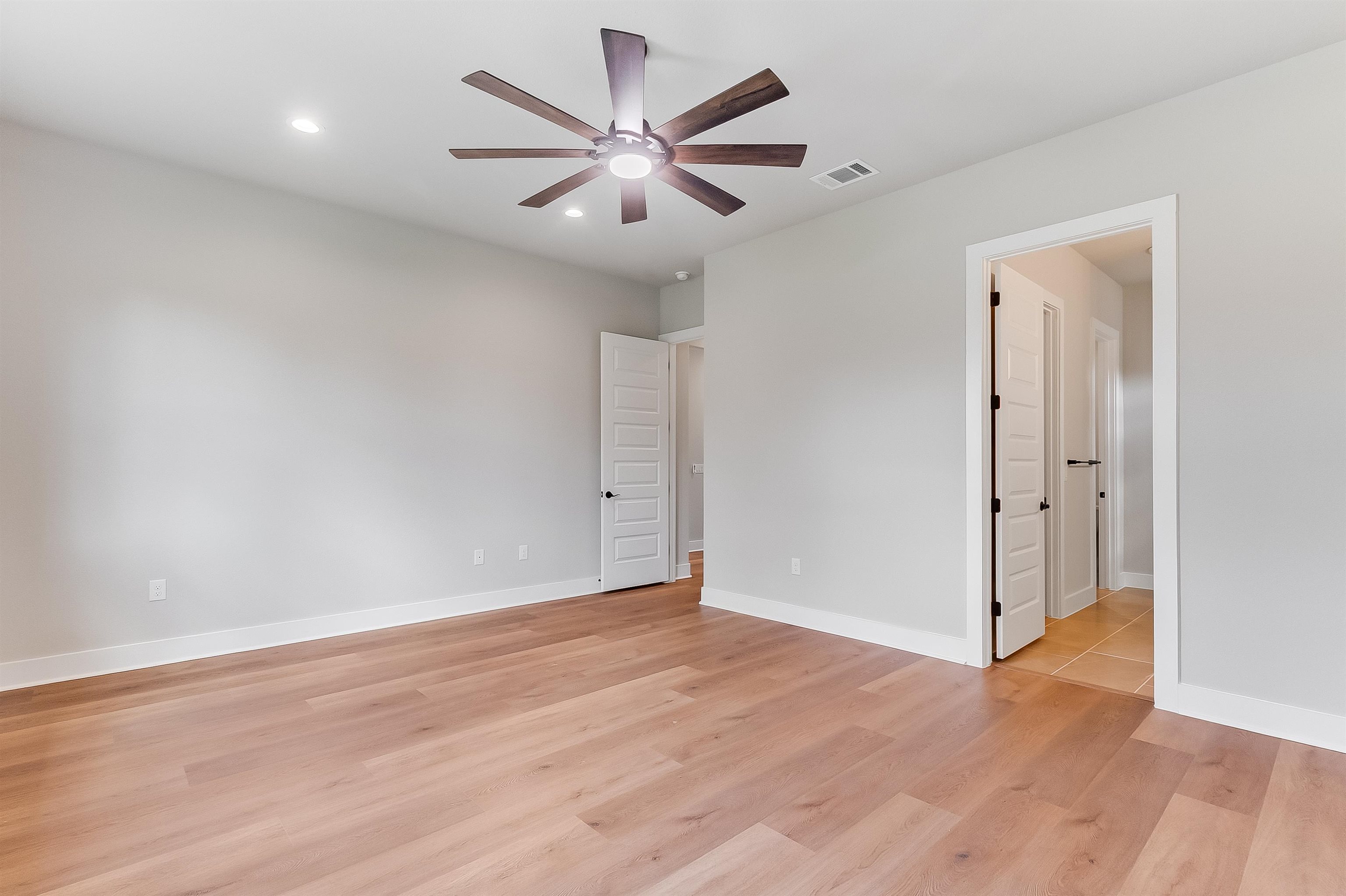 124 Draper Lane Bertram, TX 78605 - Photo 15 of 30 an empty room with wooden floor and a ceiling fan