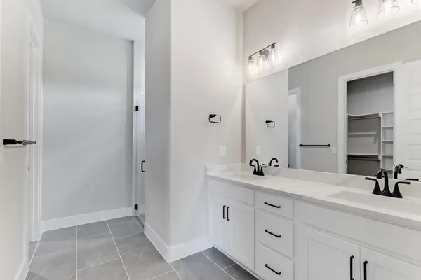 a bathroom with a double vanity sink and a mirror