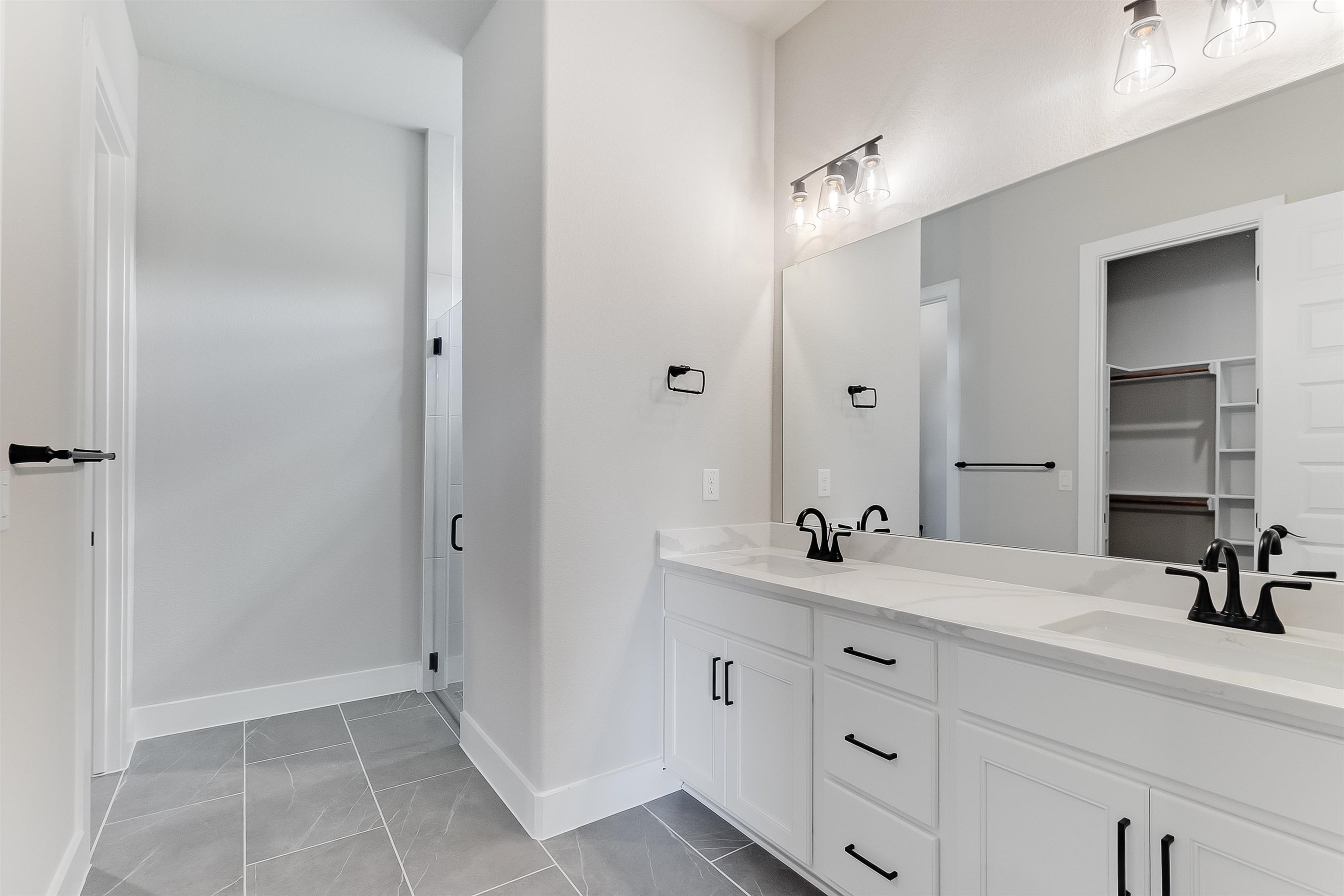 124 Draper Lane Bertram, TX 78605 - Photo 16 of 30 a bathroom with a double vanity sink and a mirror