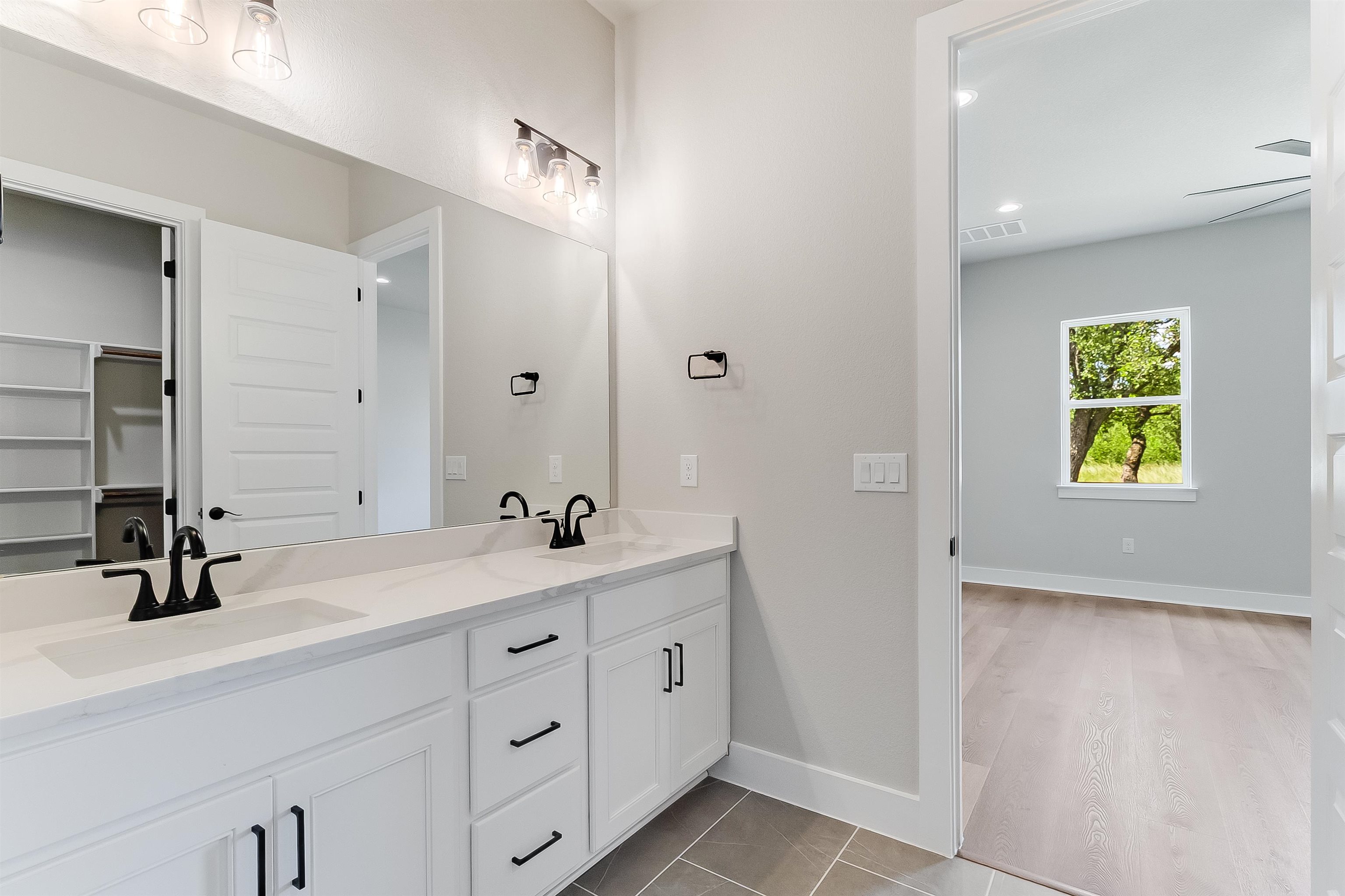 124 Draper Lane Bertram, TX 78605 - Photo 18 of 30 a bathroom with a double vanity sink and a mirror