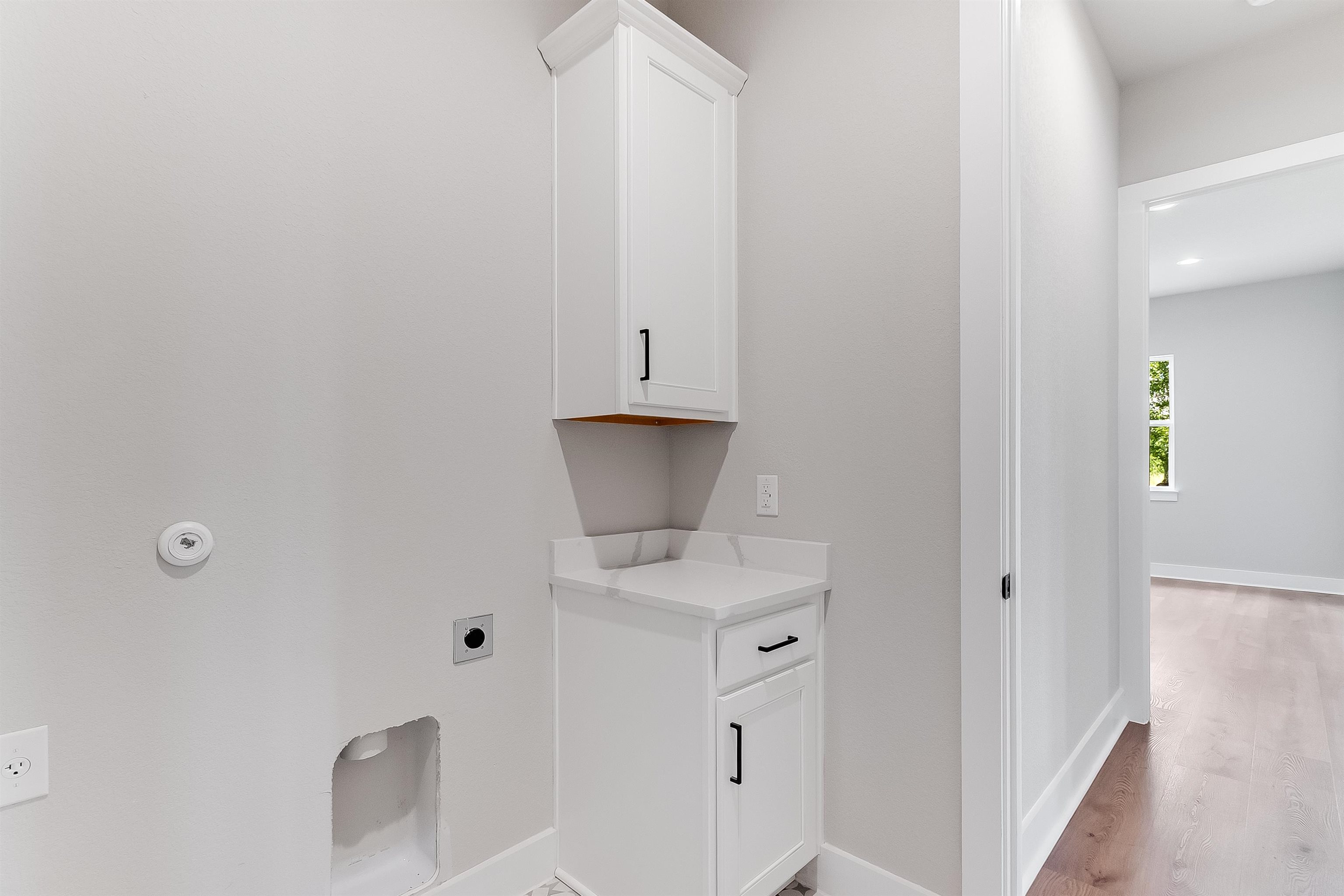 124 Draper Lane Bertram, TX 78605 - Photo 20 of 30 a bathroom with a granite countertop sink and white cabinets